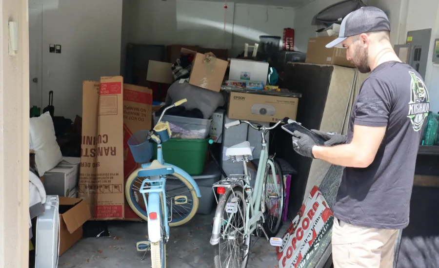 guy with ipad in front of garage full with stuff